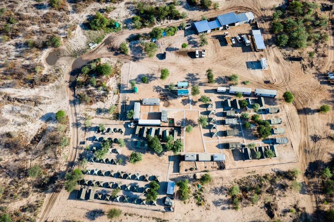 Field camp with container accommodation and vehicles on site