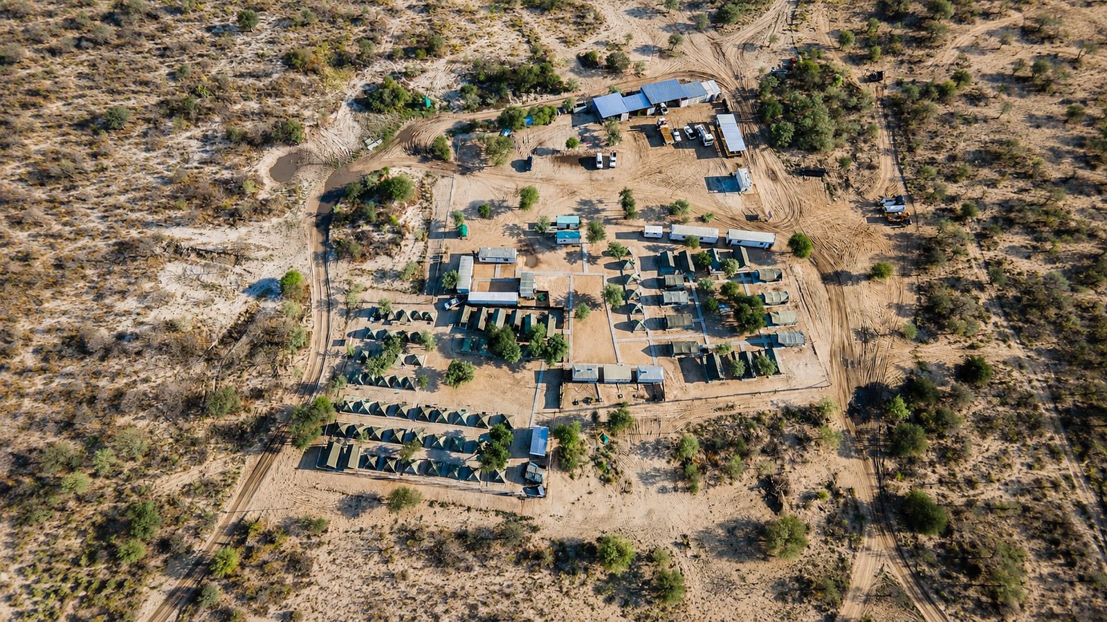 Aerial view of a Mitchell exploration camp showing tented accommodation rows, kitchen and site vehicles